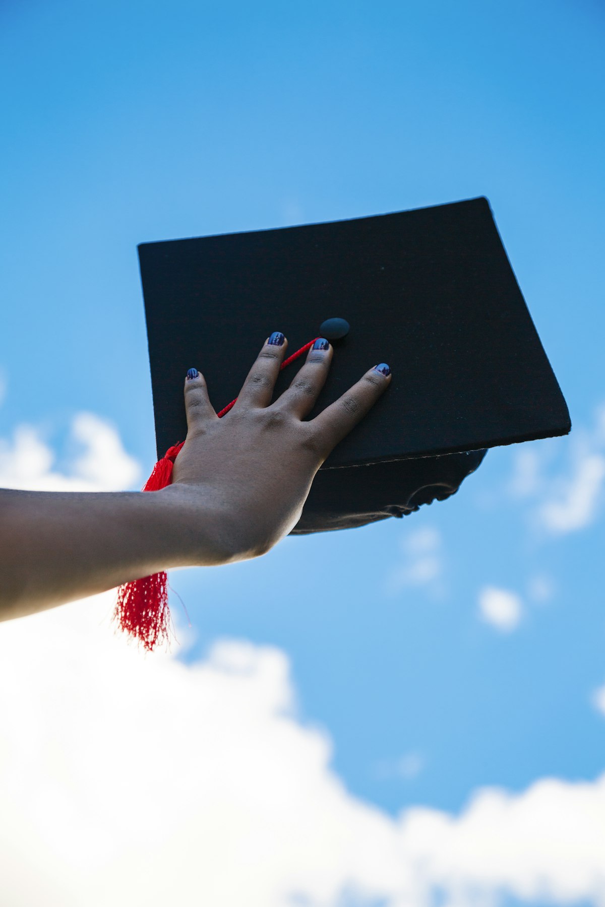 Estudante segurando capelo de formatura
